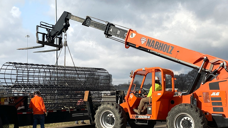 A crane lifting a large metal cage
